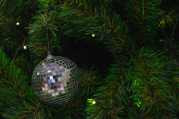 Mirrored shiny silver disco ball decorate on Christmas tree.