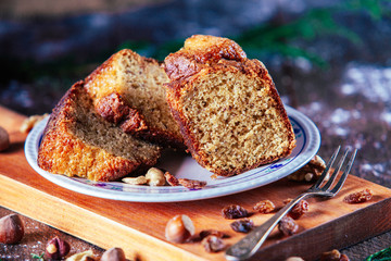 Close up Piece of homemade sponge cake of nuts, hazelnuts, nuts and raisins in rustic background