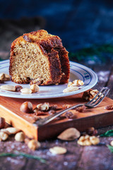 Close up Piece of homemade sponge cake of nuts, hazelnuts, nuts and raisins in rustic background