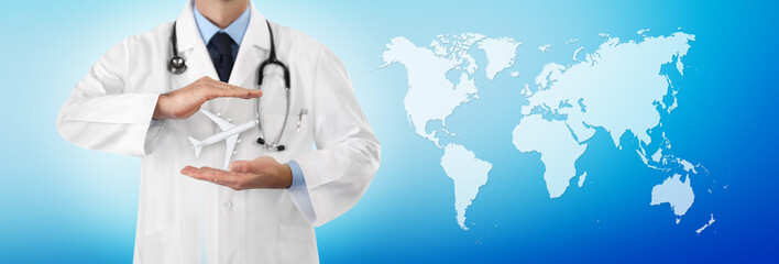 travel medical insurance concept, doctor's hands protect an airplane on blue background with world...