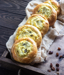 Fresh homemade open patties with cottage cheese and raisins. Traditional Russian yeast pastry vatrushka, round buns, curd tart. Buns with cottage cheese and raisins. Rustic style. Copy space.