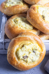 Fresh homemade open patties with cottage cheese and raisins. Traditional Russian yeast pastry vatrushka, round buns, curd tart. Buns with cottage cheese and raisins. Rustic style. Copy space.