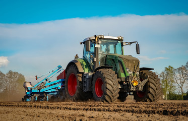Frühjahrsbestellung - Traktor mit Maislegegerät auf dem Acker