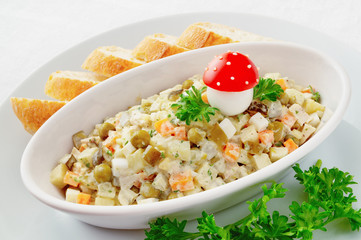 russian salad with chicken decorated with fly agaric made of quail egg, tomato, and mayonnaise 