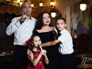 Family karaoke. Portrait of a happy family, singing in microphones