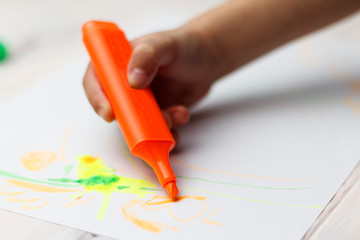 little girl draws with colored felt-tip pens. White background. have toning. close-up.