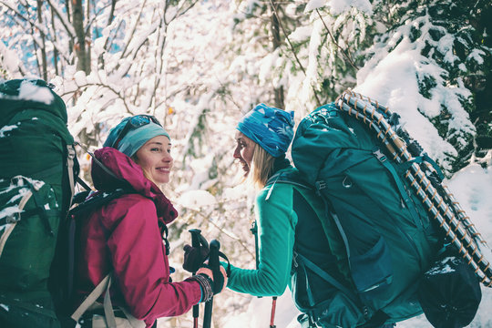 Two smiling women in a winter hike.