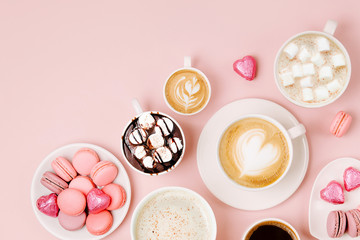 Various kinds of coffee in cups of different size with candys and macaroons on pale pink background.  Coffee  Time concept.  Flat lay, top view