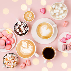 Various kinds of coffee in cups of different size with candys and macaroons on pale pink background.  Coffee  Time concept.  Flat lay, top view