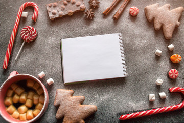 frame of sweets and Christmas tree decorations with a place for text on a blank notebook