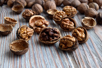 Fototapeta na wymiar Walnuts are on a wooden surface. Walnuts are shelled. The edible kernel of nut is in a shell.