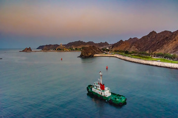 Muscat Oman Harbor, pilot boat that cruise ship out of the port, at sunset