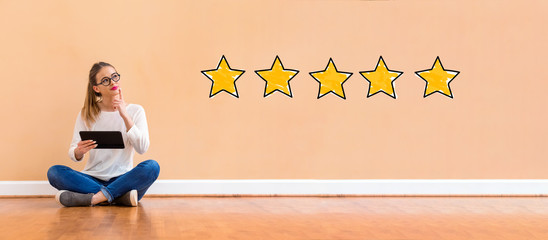 Five star rating with young woman holding a tablet computer