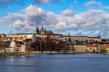 Obraz premium Prague, Czech Republic, Europe, panorama overlooking the historic buildings of Prague Castle, Charles Bridge and the Vltava River in front of interesting blue sky with clouds