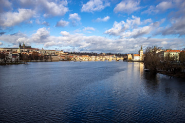 Prague, Czech Republic, Europe, panorama overlooking the historic buildings of Prague Castle, Charles Bridge and the Vltava River in front of interesting blue sky with clouds