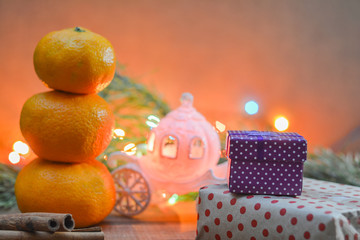 The new year mood is a snowman made from tangerines, podkarki, toy carriage and Christmas lights.