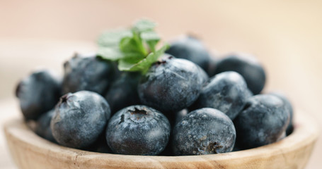 Closeup   of fresh blueberries in bowl on wood table with sack cloth