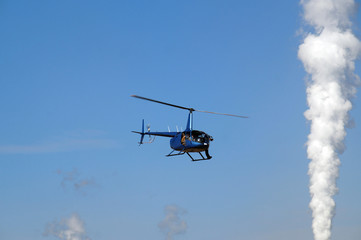 A cameraman while filming from the deck of a helicopter.