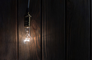 The light bulb illuminates on wooden background