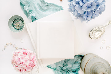 Family wedding photo album, pastel colorful hydrangea flower bouquet, turquoise blanket, decoration on white background. Flat lay, top view.