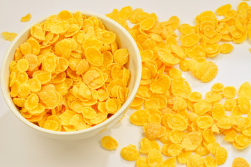 Corn flakes falling to the white bowl. Motion. Copyspace.