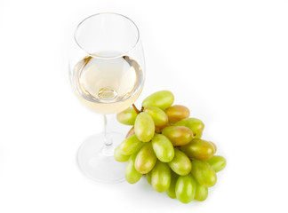 A glass of white wine with a bunch of green grapes on a white background. Alcoholic beverages.