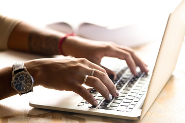 African American woman using laptop, typing on keyboard, chatting in social networks, girl writing...