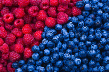 Blueberries and raspberries background. Top view.