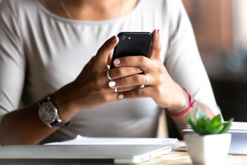 Close up woman holding smartphone, typing message, texting, chatting, female hands using cellphone,...