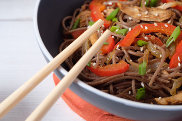 Dark pasta with steamed vegetables and grilled chicken. Delicious buckwheat noodles with vegetables...