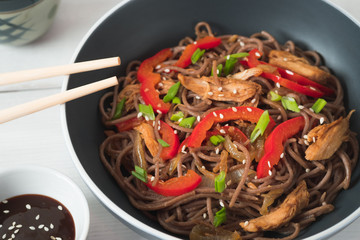 Dark pasta with steamed vegetables and grilled chicken. Delicious buckwheat noodles with vegetables...