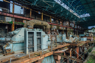 Fototapeta premium Abandoned, destroyed by war and overgrown by plants and moss machinery of Tkvarcheli (Tquarchal) power plant, Abkhazia, Georgia