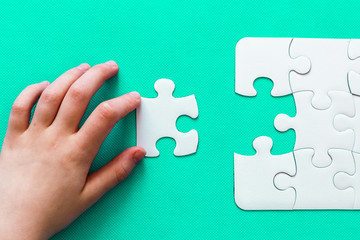 Jigsaw Puzzle with missing piece on mint background Top view People hand