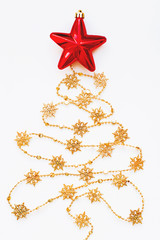 Christmas Tree made of golden snowflake garland with red bright star. New Year symbol. Flat lay, top view.