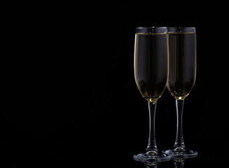 Two glasses with champagne on a black background.