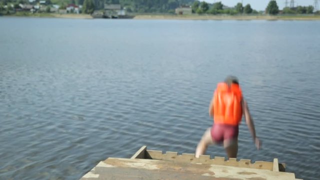 Girl in a life jacket jumping into water