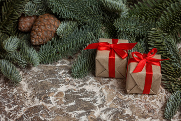 Festive Boxes with red ribbons, surrounded by cedar cones, branches and walnuts.