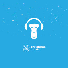 Monkey enjoys the Christmas music. Relaxing monkey in headphones. Logotype with snowflake.