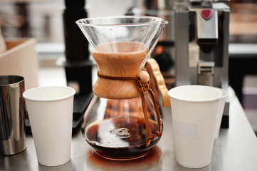 Kemeks and two paper disposable cups. Drip brewing coffee.