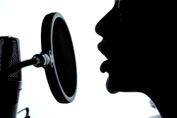 Sensual woman sexy silhouette profile with pretty face near studio microphone. A girl with opened...