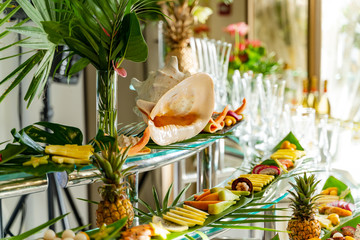 Beautifully decorated delicious table with fresh exotic organic fruits on a buffet table for a party goodies. Assorted diversity of fresh exotic fruits.