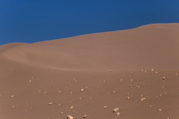 Big sand dune with stones on its slope