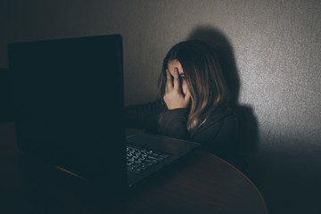 Teenager girl suffering internet cyber bullying scared and depressed cyberbullying. Image of...