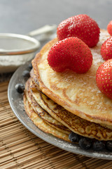 Pancakes with strawberries on a plate. Sweet breakfast or snack.