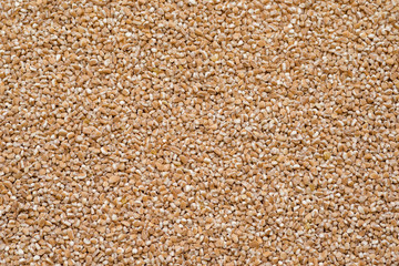 Crushed Spelt wheat, raw spelt porridge, top view, abstract background
