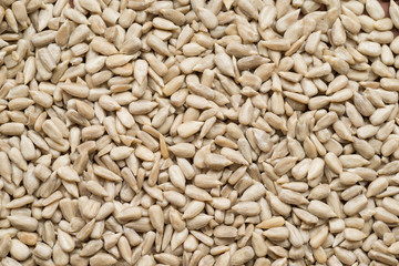Raw sunflower seeds peeled, top view, abstract background