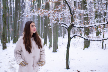 Outdoor portrait of young pretty beautiful woman in cold sunny winter weather in park. Season of Winter. Outdoors.