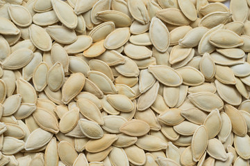 Raw white pumpkin seeds, top view, abstract background