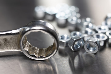 Wrench and nuts on a metal table in a workshop. Accessories for mechaics for minor mechanical...