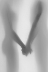 Diffuse silhouette and body parts of a lover couple, hands